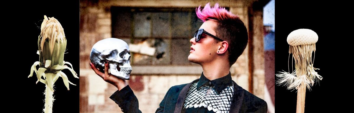 A white woman dressed in black with short, spiky pink hair and sunglasses holds and contemplates a human skull. Flanking the image are photos of a dandelion bud and a dandelion that has lost its seeds.