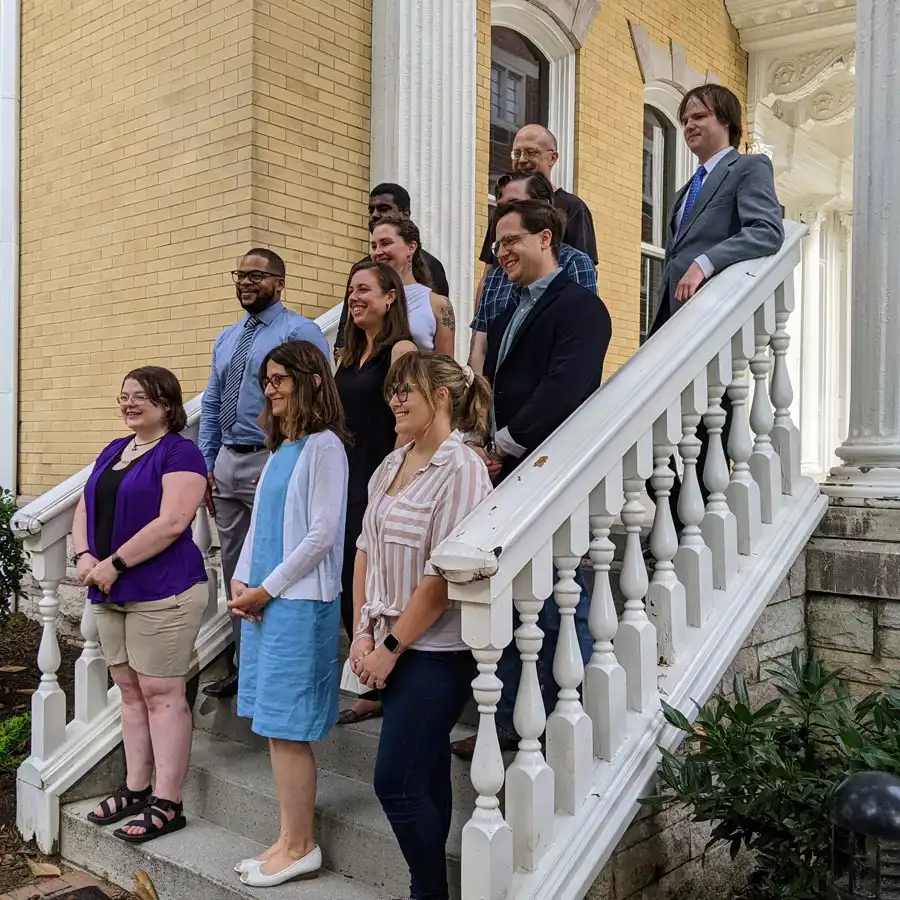 Humanities Fellows stand on steps of the Alumni House to be photographed
